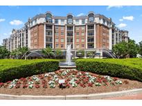 Striking brick condo building with water feature and manicured landscaping adds luxury to the community at 4625 Piedmont Row Dr # 712, Charlotte, NC 28210