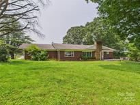Charming brick ranch-style home with a lush lawn and mature trees offering serene curb appeal at 61 23Rd Nw St, Hickory, NC 28601