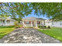 Charming single story home featuring a cozy front porch, red shutters, and a well manicured lawn at 611 Church St, Belmont, NC 28012