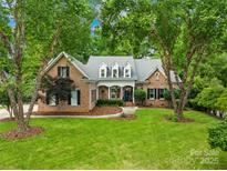 Charming brick home with manicured lawn and mature trees offering great curb appeal at 7229 Olde Sycamore Dr, Mint Hill, NC 28227