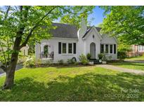 Charming one-story white brick home featuring a manicured lawn, covered porch, and beautifully mature trees at 772 Eden Ter, Rock Hill, SC 29730