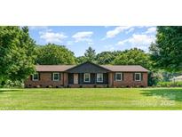 Charming brick ranch-style home with a lush front lawn and mature trees, creating a serene curb appeal at 9410 Mountain Aire Cir, Charlotte, NC 28214