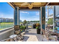 A covered patio with a fan, outdoor seating, and a view of the lake at 1007 Southwest Dr, Davidson, NC 28036