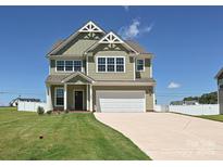 Charming two-story home features a two-car garage, well-maintained lawn, and classic architectural details at 11507 Valley Oak Ln, Stanfield, NC 28163