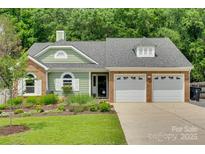 Charming home featuring a well-manicured lawn, beautiful landscaping, and a two-car garage at 11615 Chadburn Ln, Charlotte, NC 28215