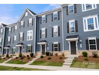 Charming townhome featuring a landscaped front yard and a welcoming entrance, showcasing modern design and curb appeal at 1204 May Apple Dr, Matthews, NC 28104