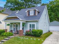 Charming two-story home featuring manicured lawn, a detached garage, and lovely curb appeal at 1228 Rising Oak Dr, Charlotte, NC 28206