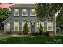 Charming two-story home with a well-manicured lawn, decorative shrubs, and a welcoming front entrance at 13010 Indian Hills Ln, Charlotte, NC 28278