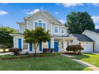 Charming two-story home with a well-manicured lawn, blue shutters, and an attached garage at 15280 Leslie Brook Rd, Huntersville, NC 28078