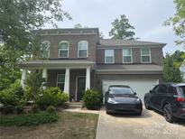 Charming brick two-story home with a welcoming front porch and well-maintained landscaping at 15636 Oleander Dr, Charlotte, NC 28278