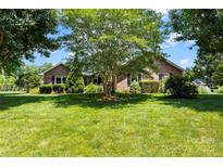 Charming brick home featuring a well-maintained lawn and mature trees at 1958 Cameron Heights Cir, Denver, NC 28037