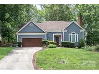 Charming home featuring blue siding, a well-manicured lawn, and an attached two-car garage at 2133 Highland View Ln, Charlotte, NC 28214