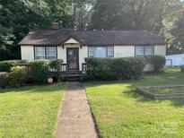Charming single-story home with a well-manicured lawn and established landscaping at 2411 Rebecca Ave, Charlotte, NC 28208