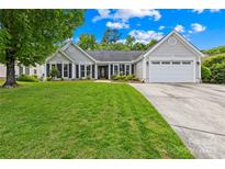Charming single-story home featuring a well-maintained lawn, gray siding, black shutters, and an attached two-car garage at 4313 Wynborough Ln, Charlotte, NC 28269