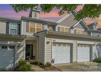 Charming townhome with attached two-car garage, complemented by manicured landscaping and warm exterior lighting at 460 Clouds Way, Rock Hill, SC 29732