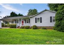 Charming single-story home featuring a welcoming front porch, red front door, and well-maintained lawn at 5445 Creekwood Dr, Salisbury, NC 28147