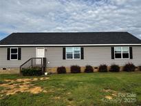 Charming single-story home with gray siding, black shutters, and well-maintained landscaping at 5707 S Rocky River Rd, Monroe, NC 28112
