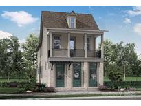 Charming two-story home with a balcony, complemented by lush landscaping and a welcoming front yard at 641 Hops Aly, Fort Mill, SC 29715