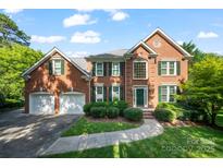 Beautiful two-story brick home featuring a well-manicured lawn and a two-car garage at 8900 Cumbria Ct, Huntersville, NC 28078