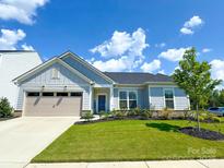 Charming single-Gathering home with a well-manicured lawn and a two-car garage on a sunny day at 11031 Larkslea Ln, Charlotte, NC 28278