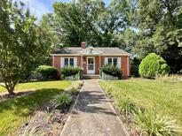 Charming brick home featuring a well-manicured front yard and inviting walkway at 310 E Houston St, Monroe, NC 28112