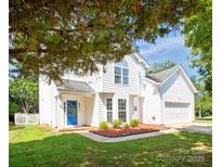 Charming two-story home featuring a bright blue front door, white siding, and a well-manicured front yard at 411 Carlisle Dr, Indian Trail, NC 28079