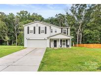 Charming two-story home featuring a well-manicured lawn, two car garage, and a welcoming front porch at 473 Wendover Dr, Salisbury, NC 28147