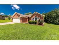 Charming single-story red brick home with a two-car garage and well-manicured front lawn at 511 Birmingham Ct, Rock Hill, SC 29732