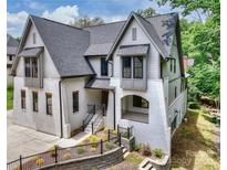 Stunning two-story home featuring a white brick facade, stylish gabled roof, and manicured landscaping at 7011 Chateau Bordeaux Ln, Charlotte, NC 28270