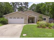 Charming single-story home with an attached garage and a well-manicured front lawn at 7164 Moss Point Dr, Charlotte, NC 28277