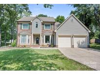 Charming two-story home featuring brick and siding, large bay windows, and a manicured front lawn at 1045 Fairway Ridge Nw Rd, Concord, NC 28027