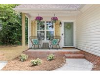 Charming front porch with comfortable seating and decorative hanging flower baskets at 3100 Hickory Grove Dr, Monroe, NC 28110