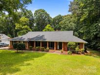Charming one-story brick home with a cozy front porch and lush green lawn at 324 Swamp Fox Dr, Fort Mill, SC 29715