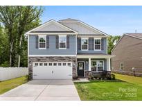 Charming two-story home with stone accents, well-manicured lawn, and an attached two-car garage at 3734 Stanley Creek Dr, Mount Holly, NC 28120