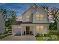 Charming two-story home showcasing a well-manicured lawn and an attached garage, perfect for a Gathering at 3855 Tersk Dr, Midland, NC 28107