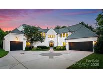 Stunning white brick home with a circular driveway, two-car garage, and manicured landscaping at 4714 Ockley Manor Ln, Charlotte, NC 28226