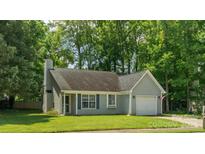 Charming single-story home with a manicured lawn, attached garage, and inviting front entrance at 5019 Poplar Glen Dr, Matthews, NC 28104