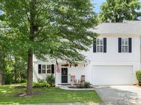 Charming white home featuring a well-kept lawn and inviting front porch with rocking chairs at 705 Torrey Pines Ln, Fort Mill, SC 29715