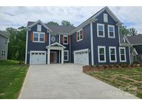 New construction home with blue siding, white trim, and a two-car garage plus a one car garage at 8231 Annsborough Nw Dr, Concord, NC 28027