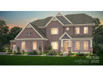 Stunning brick home with beautiful landscaping and a welcoming front entrance and a two-car garage at 9112 Ansley Park Pl # 266, Huntersville, NC 28078
