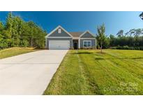 Charming single-story home with a well-manicured lawn and attached two-car garage at 10180 Lakeshore Dr, Lancaster, SC 29720
