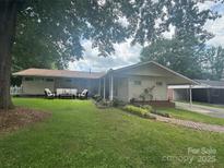 Charming single-story home featuring a brick facade, cozy outdoor seating, and a well-manicured lawn at 1107 Crestfield Dr, Lancaster, SC 29720