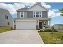Charming two-story home featuring gray siding, a two-car garage, landscaped front yard, and a welcoming front porch at 120 Parson Ln, Statesville, NC 28625