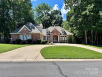 Charming brick home with lush lawn, landscaped garden and circular driveway at 125 Highland Forest Dr, Clover, SC 29710