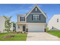 Charming two-story home boasts a classic design, complemented by a well-manicured lawn and a two-car garage at 140 Astor St, Troutman, NC 28166