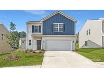 Charming two-story home with a modern exterior, a two-car garage, and manicured landscaping at 144 Astor St, Troutman, NC 28166
