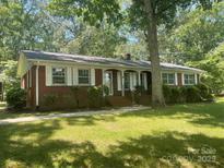 Charming single-story brick home with white shutters and a well-manicured lawn, surrounded by mature trees at 2120 Marwood Ln, Albemarle, NC 28001