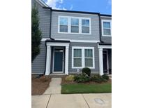 Charming townhome featuring gray siding, white trim, a quaint front garden, and a welcoming teal front door at 334 Ladybird Ln, Pineville, NC 28134