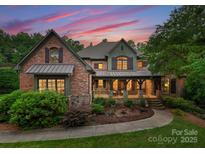 A charming two-story home with a brick facade, stone accents, and a welcoming front porch at 408 Covington Xing, Matthews, NC 28104