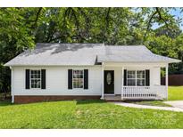 Charming single-story home with black shutters, a well-manicured lawn, and a quaint front porch at 429 Merry Go Dr, York, SC 29745